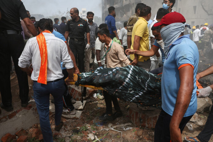Pessoas carregam o corpo de uma vítima do local do acidente após um avião Boeing 787 Dreamliner da Air India cair em Ahmedabad | REUTERS/Amit Dave