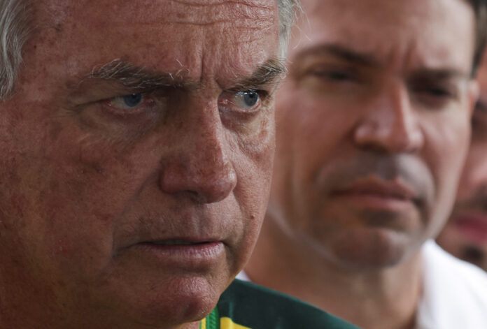 O ex-presidente Jair Bolsonaro fala com a imprensa observado por Alexandre Ramagem | REUTERS/Ricardo Moraes