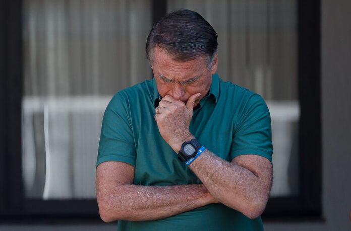 O ex-presidente Jair Bolsonaro na garagem de sua casa, em Brasília. Bolsonaro ficou por cerca de 25 minutos no local, ao lado do irmão de sua esposa, Eduardo Torres, acenando para fotógrafos e transeuntes | Foto: Pedro Ladeira/Folhapress