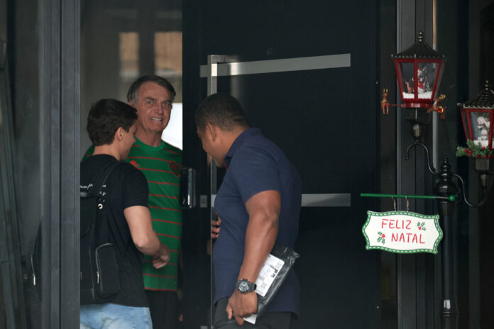 O ex-presidente do Brasil, Jair Bolsonaro, aparece na porta de sua casa, durante sua prisão domiciliar, em Brasília | REUTERS/Mateus Bonomi O ex-presidente do Brasil, Jair Bolsonaro, aparece na porta de sua casa, durante sua prisão domiciliar, em Brasília | REUTERS/Mateus Bonomi