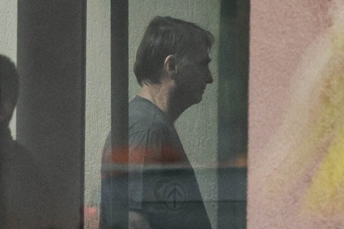 Jair Bolsonaro na Polícia Federal em Brasília O ex-presidente Jair Bolsonaro é visto através do vidro da sede da Polícia Federal, em Brasília, durante sua permanência no local ao longo das investigações que motivaram sua condução. A cena mostra Bolsonaro no interior do prédio, observado pela equipe de segurança | Gabriela Biló/Folhapress